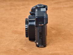 Black Mamiya 7 II rangefinder camera. Side view.