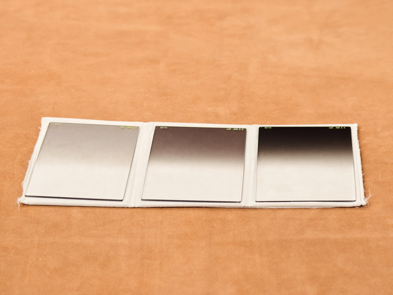Set of three LEE 100x150mm soft grad neutral density optical resin filters laid flat in fabric sleeve